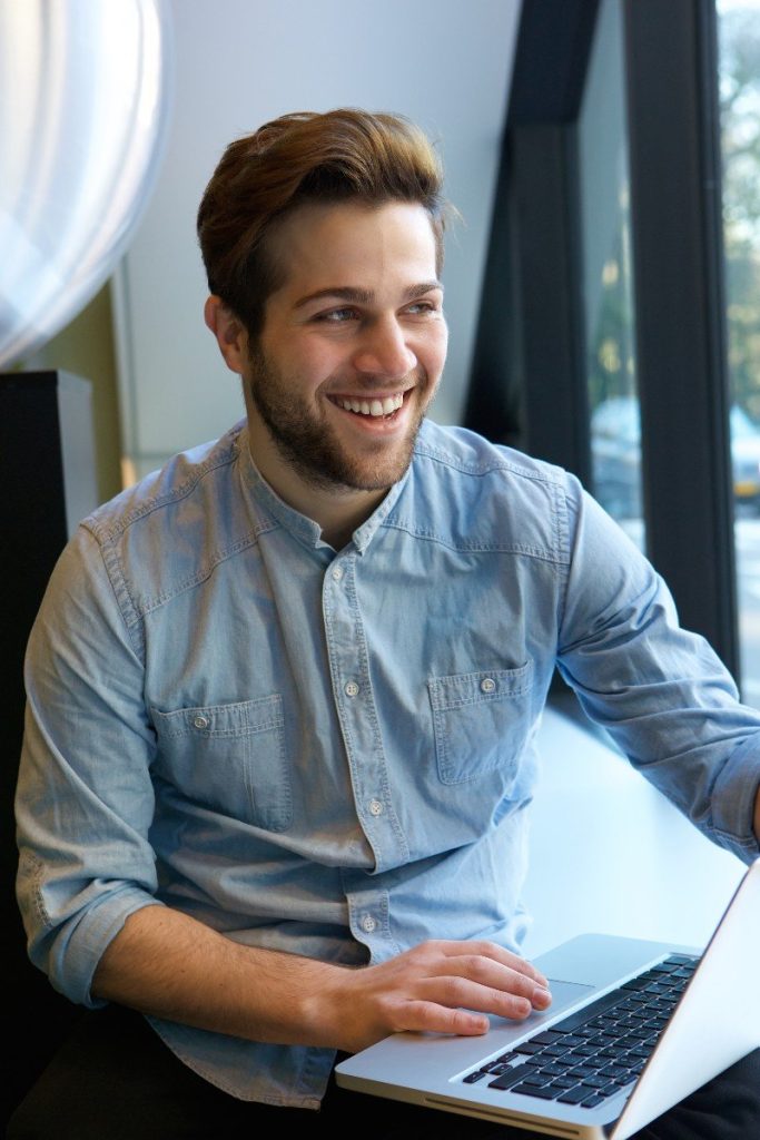 A confident person sitting with laptop in an office